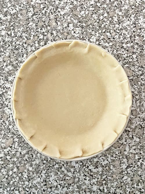 pie crust with scalloped edges in a pie pan pecan pie