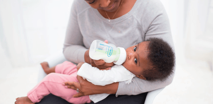 woman feeding a baby a bottle feeding a breastfed baby