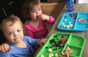 Twins eating at a table.