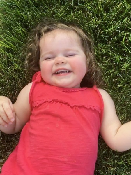 girl in grass smiling strong-willed child