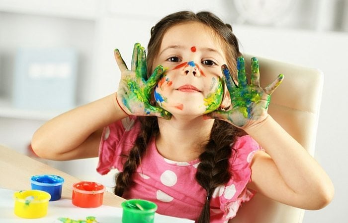kid with paint on her palms, finger-painting
