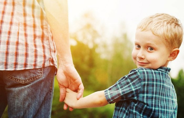 boy holding adult hand