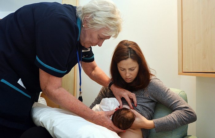 lactation consultant helping a mom get ready for breastfeeding twins