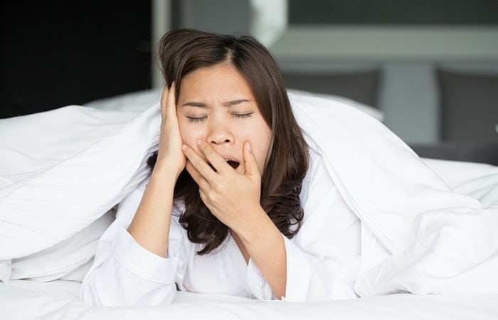 parenting lessons woman yawning in bed