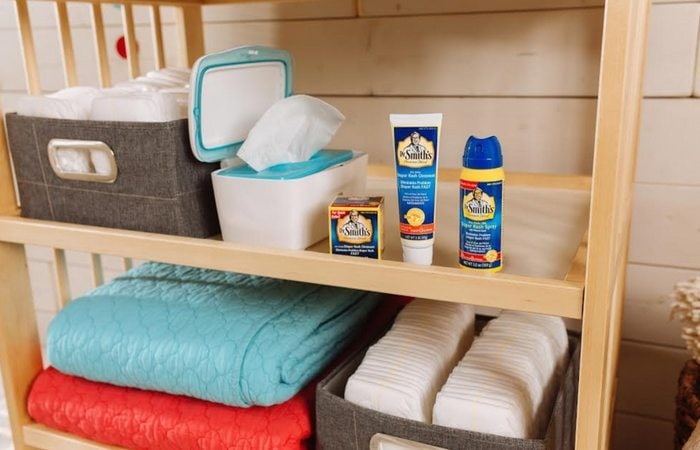Dr Smith's on a shelf with blankets, diapers and wipes