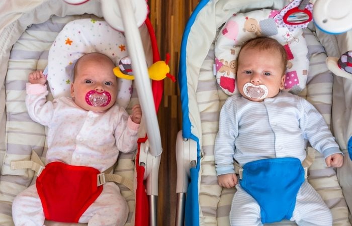 boy girl infant twins in bouncy seats
