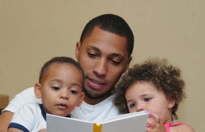 Dad reading to twins