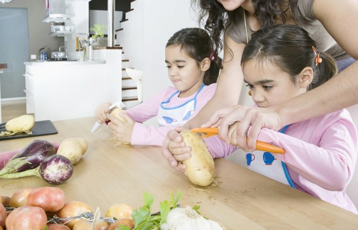 twin girls helping in kitchen