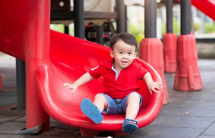 boy at bottom of slide in park
