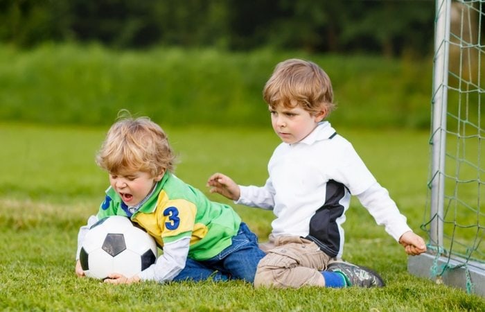 2 boys fighting over soccer ball