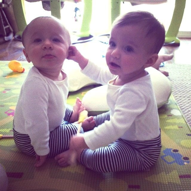 twin babies sitting on the floor out the door with twins