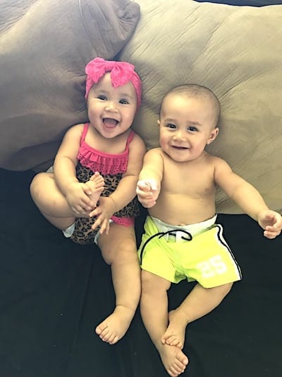 silly questions boy girl twin babies smiling on a couch