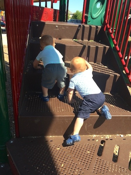 twins climbing up playground gym need to crawl