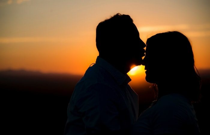 silhouette of man kissing woman's forehead love language infertility treatments