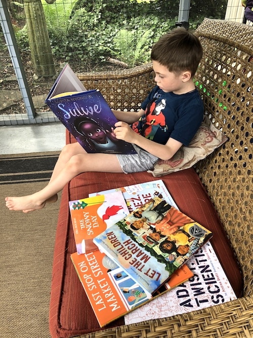 boy reading books to diversify
