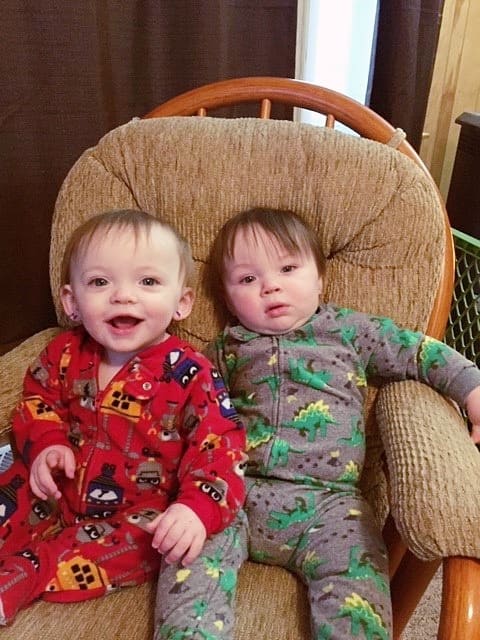 twin boys 1 year olds sitting in a chair together ear tubes