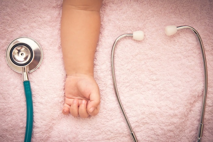 child's arm and stethoscope emergency room