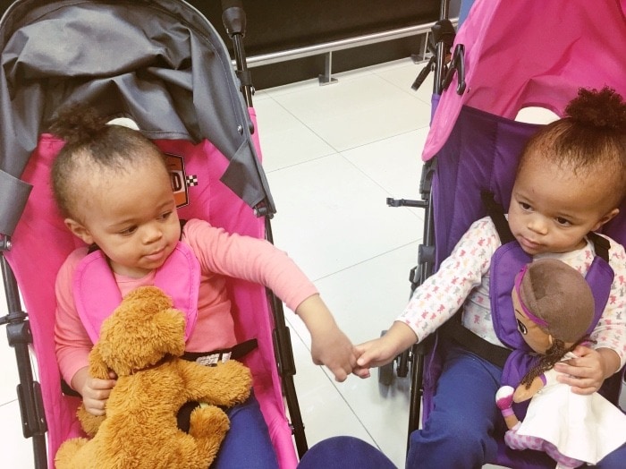 twins in strollers holding hands family vacation