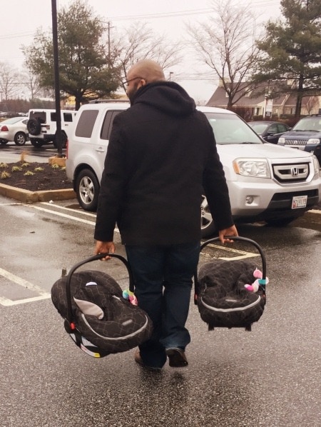 dad carrying car seats family vacation