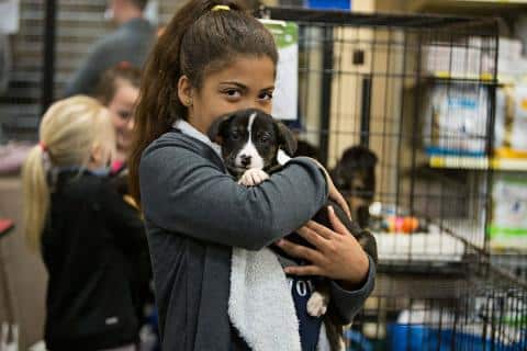 girl holding puppy kids reach their goals