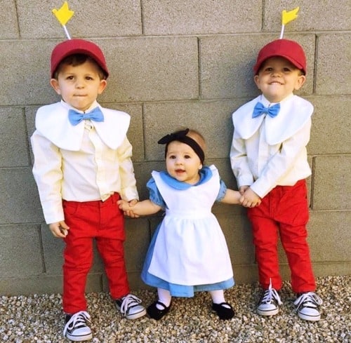 twin boys dressed up as tweedle dee and tweedle dum and their baby sister in the middle dressed up as Alice in Wonderland