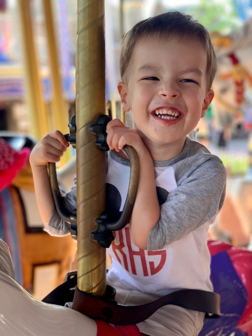 boy riding carousel disney world alone