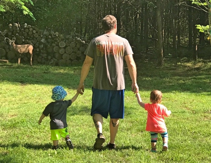 dad walking in grass with toddler twins welcome spring