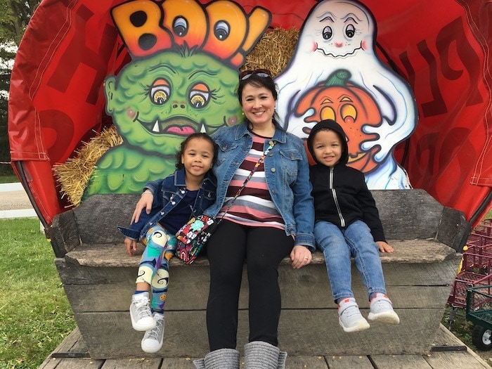 Mother with Twin girls on bench, smiling