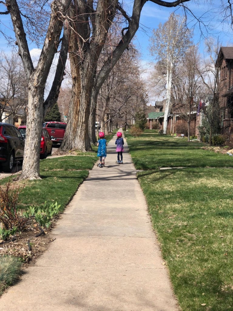 two girls walking down a sidewalk not traveling