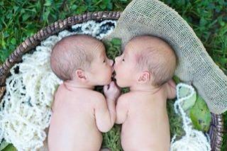 newborn twins snuggling in a basket