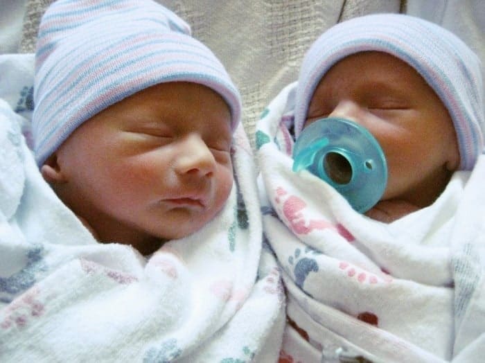 newborn twins sleeping and wrapped in blankets