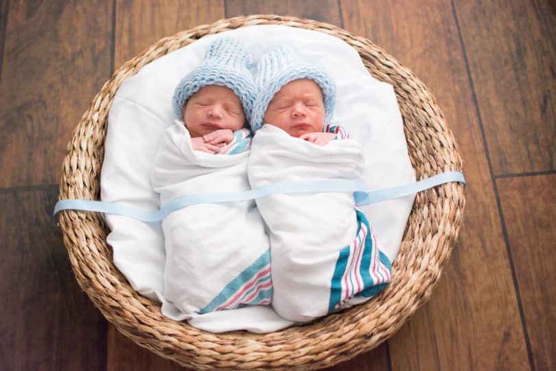 newborn twins swaddled in a basket