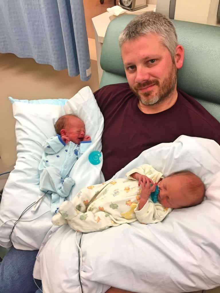 dad holding twins time in the nicu