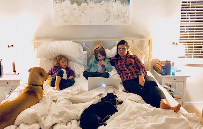 twin girls and mom in bed with 2 dogs