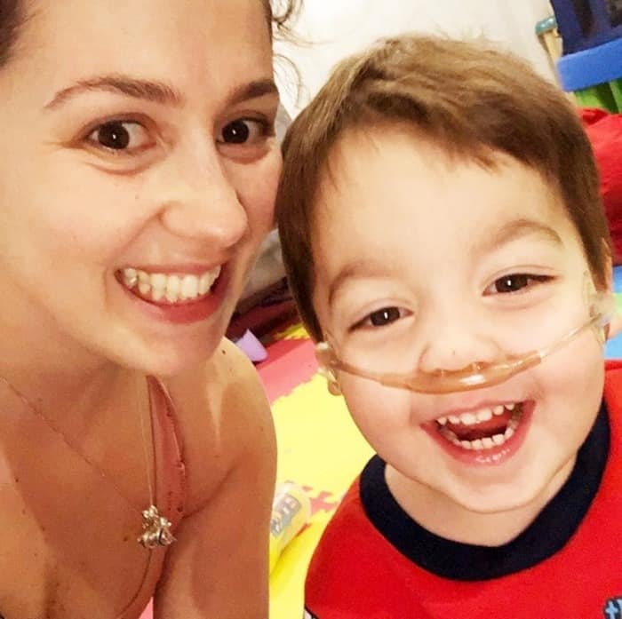 Woman and child in selfie using portable oxygen tank