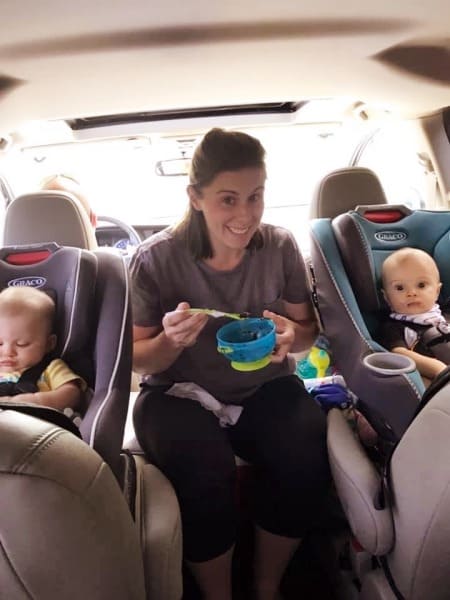 mom feeding babies in car road trips with twins