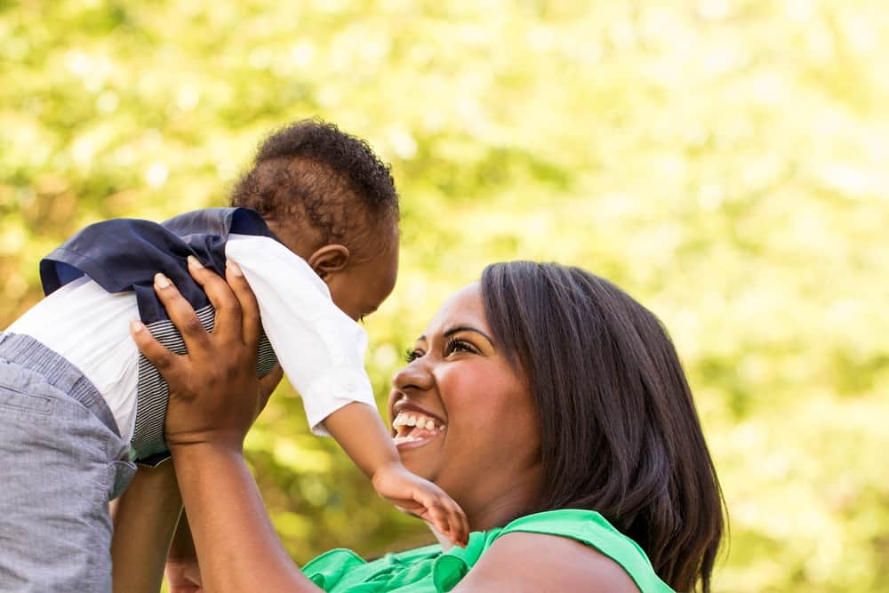 mom holding up baby