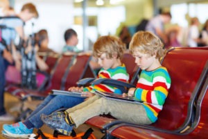 twins sitting at airport twin travel