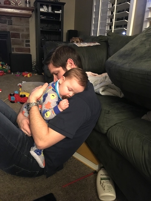 dad holding sick little boy cold and flu season