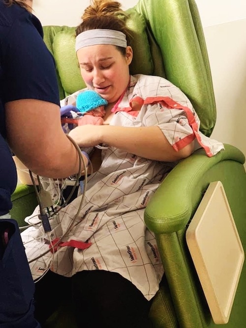 mom holding premature baby in NICU signs of preterm labor