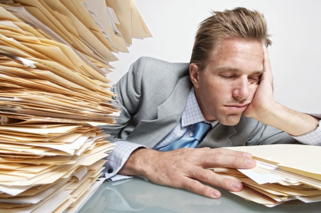 man sleeping at desk sleep deprived