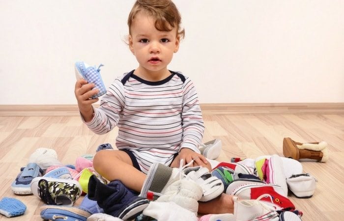 toddler in a pile of shoes let it go