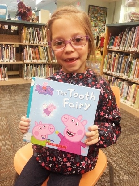 girl holding book tooth fairy