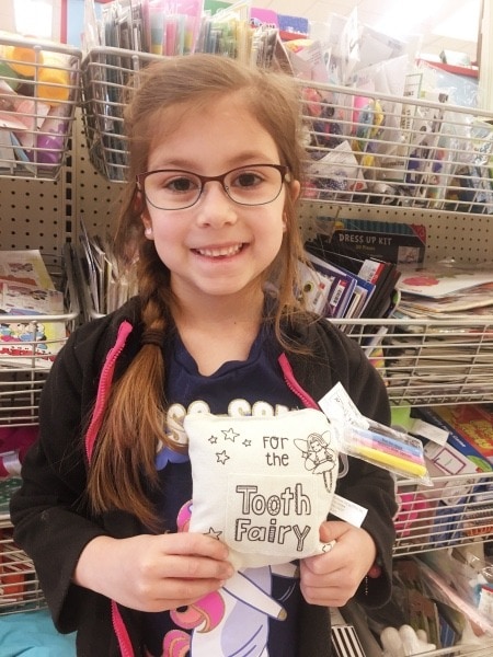 girl holding tooth fairy pouch