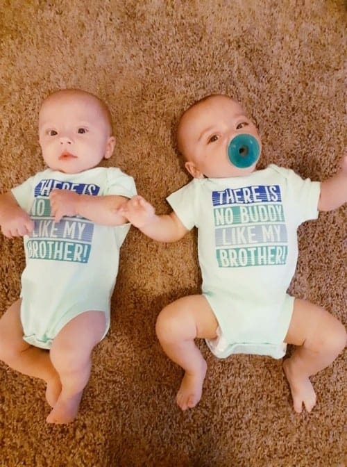 twin babies laying on the carpet twin parents