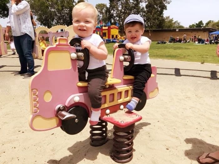 twins on a bouncy playground firetruck ride twin parents