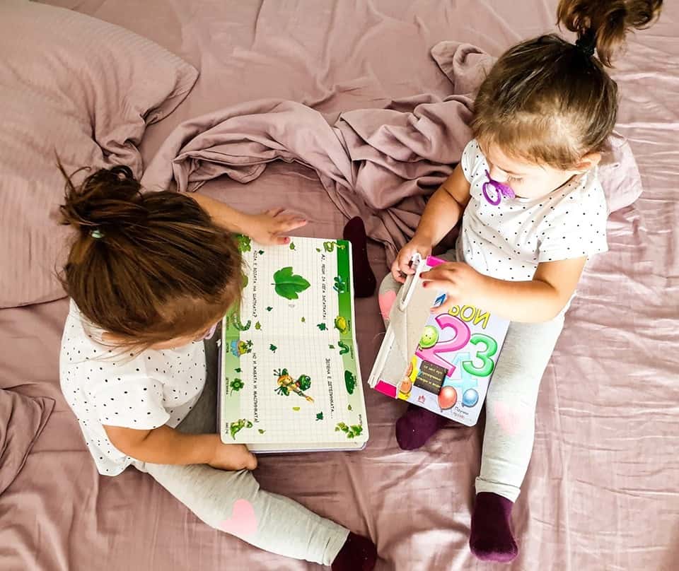 twin toddler girls reading books together twin parents