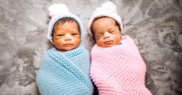 newborn boy girl twins laying down in swaddles twin parents