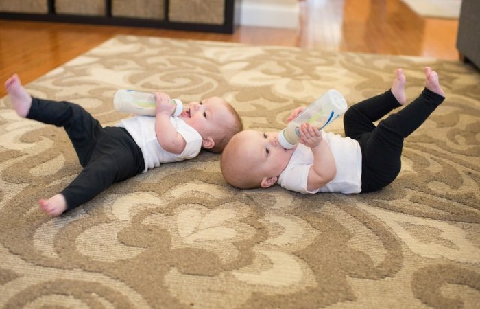 twin babies on floor bottle feeding hacks