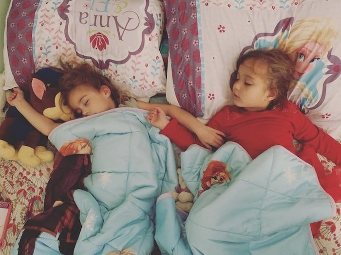 twin girls asleep in bed during a pandemic